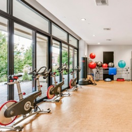a group of spin bikes and medicine balls