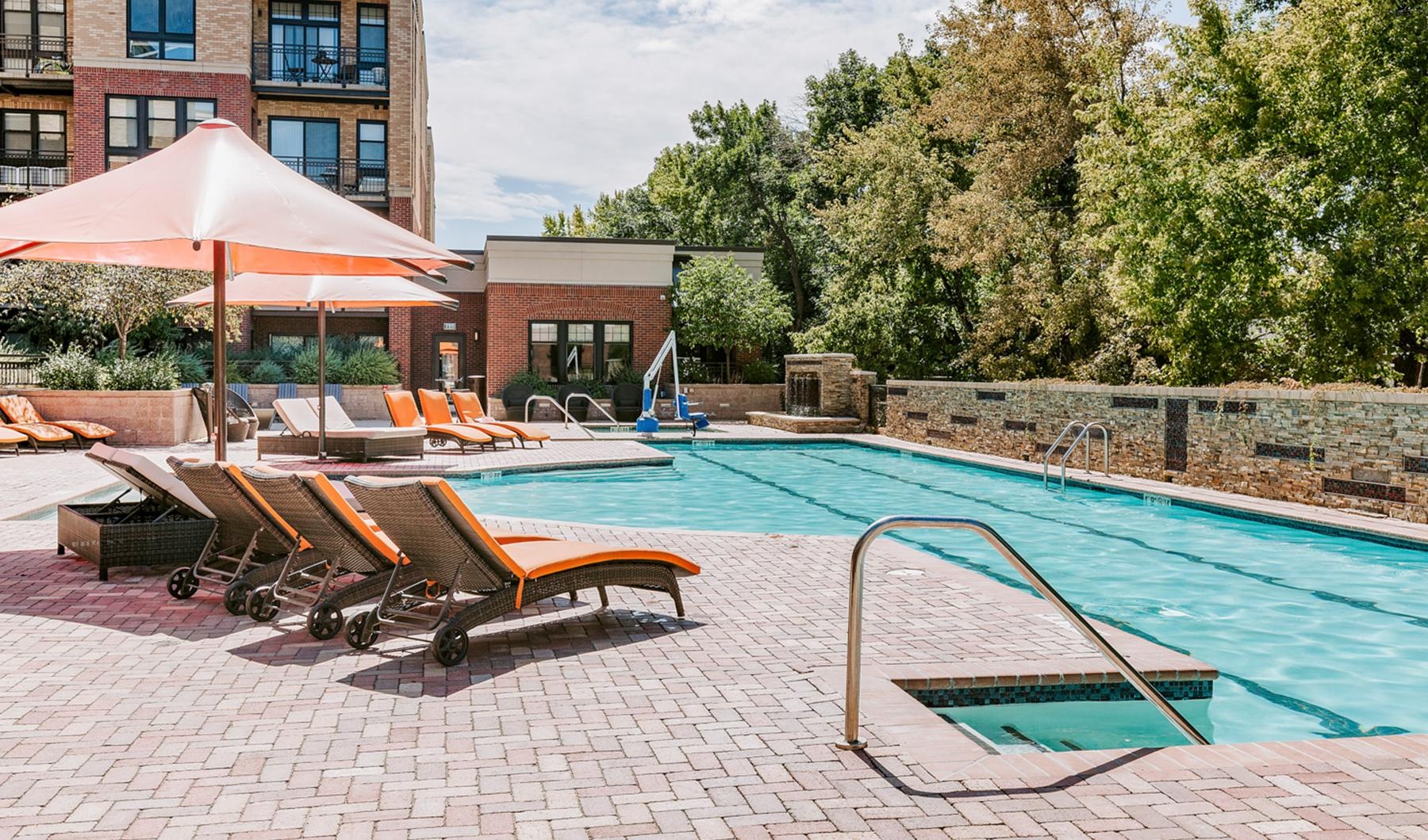 Resort-style swimming pool a pool with lounge chairs and umbrellas